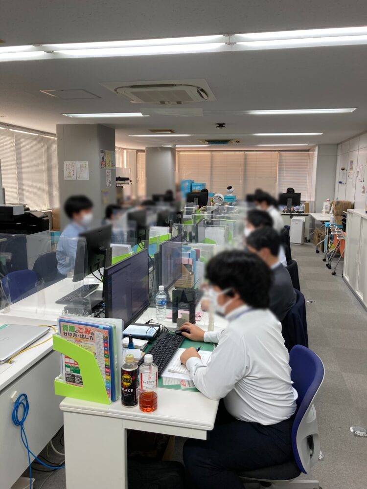 オフィスで机を並べてPC作業をしている様子