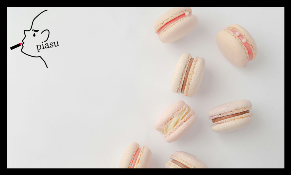 可愛い薄いピンクのマカロンが7個、白いテーブルの上に置かれている