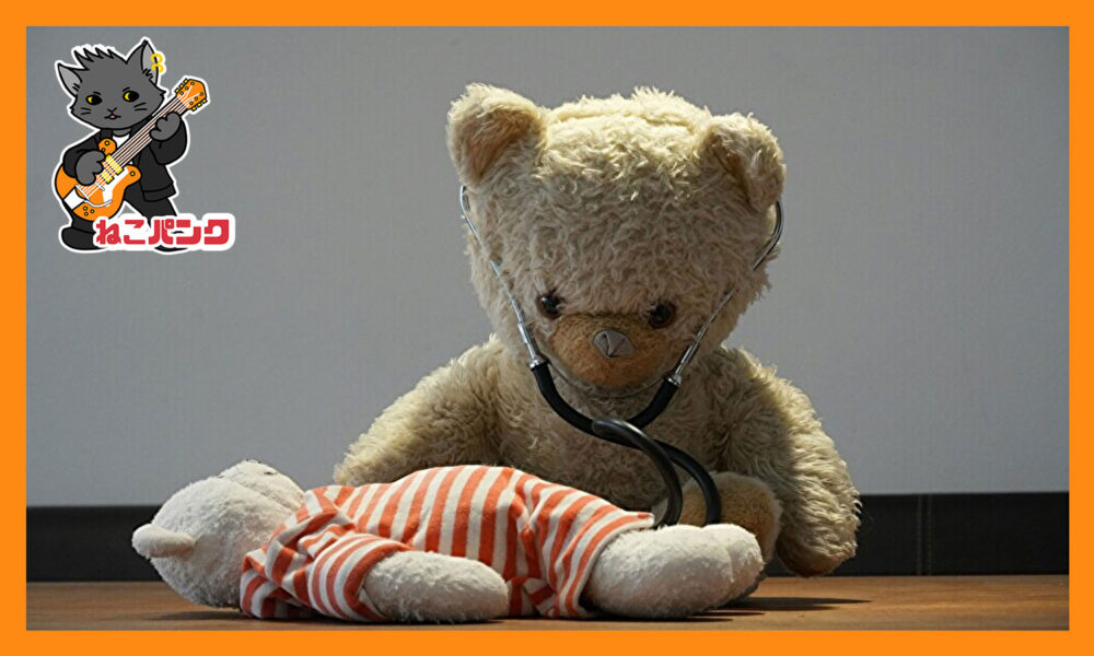ぬいぐるみのクマ先生がぬいぐるみの子グマを診察している画像