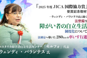 車いすの女性と『2025年度JICA国際協力賞』受賞記念取材-ウェンディ・バランテス氏に聞く法整備等障がい者の自立生活制度化について、法整備に導いた280㎞の車いす行進コスタリカ障がい者自立生活センター「モルフォ」代表ウェンディ・バランテス氏と書かれたテキスト