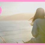 海を眺めている女性の後ろ姿