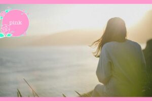 海を眺めている女性の後ろ姿