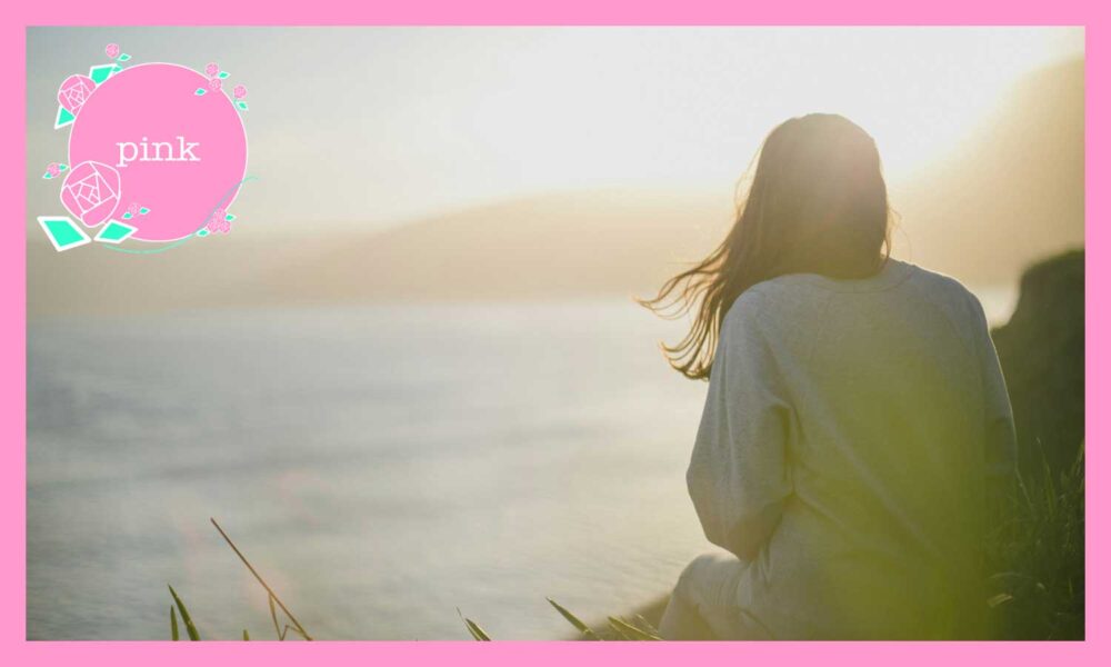 海を眺めている女性の後ろ姿