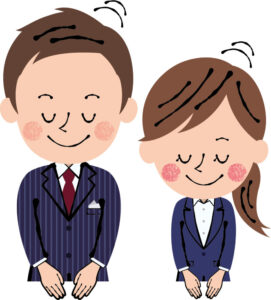 男性と女性が笑顔でお辞儀をしている。