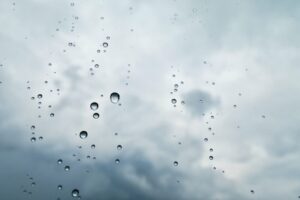 ガラス越しに、雨が降っていえう。水滴が、窓のようなものについている。