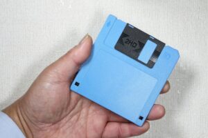 左手で3.5インチサイズのフロッピーディスクを持つ