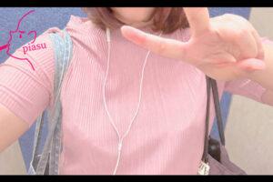 ピンクの服を着たピースをした女の子の上半身
