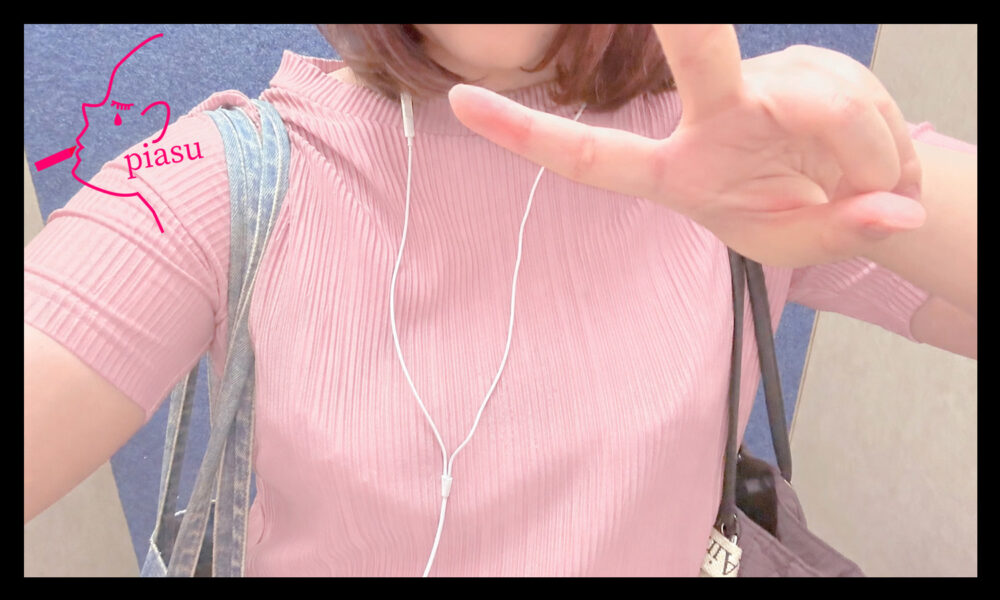 ピンクの服を着たピースをした女の子の上半身