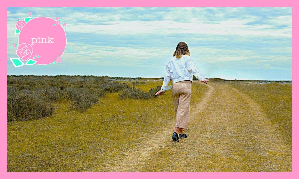 一本道を歩いている女性の後ろ姿