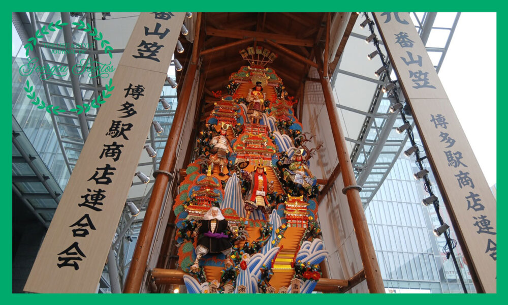 博多駅前に飾られた博多祇園山笠の九番山笠の飾り山で武者の人形や鮮やかな装飾が何段にも重ねられている様子
