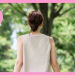 髪をアップにして、白のノースリーブを着ている女性の後ろ姿