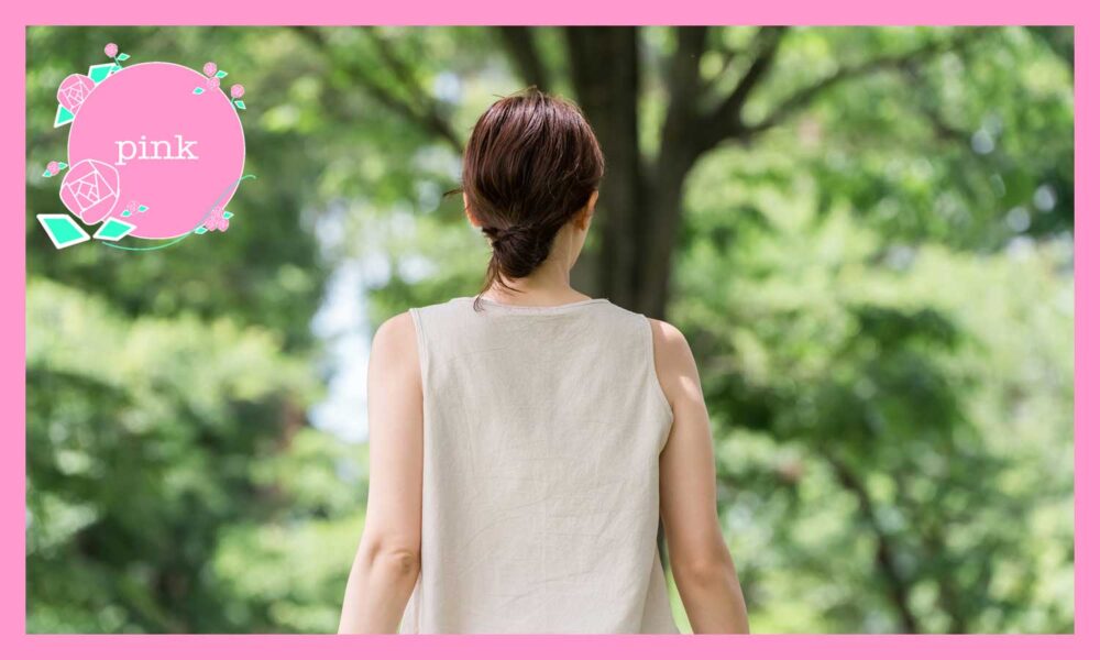 髪をアップにして、白のノースリーブを着ている女性の後ろ姿