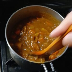 カレールーを鍋に入れ煮込んでカレーを完成させている様子