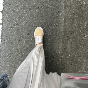 スカートを履いた女性が歩いている姿黄色い靴を履いている