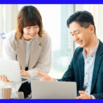パソコン業務を教える男性と教わる女性